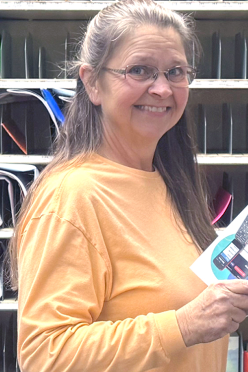 A woman with long hair wearing a light orange long-sleeve shirt