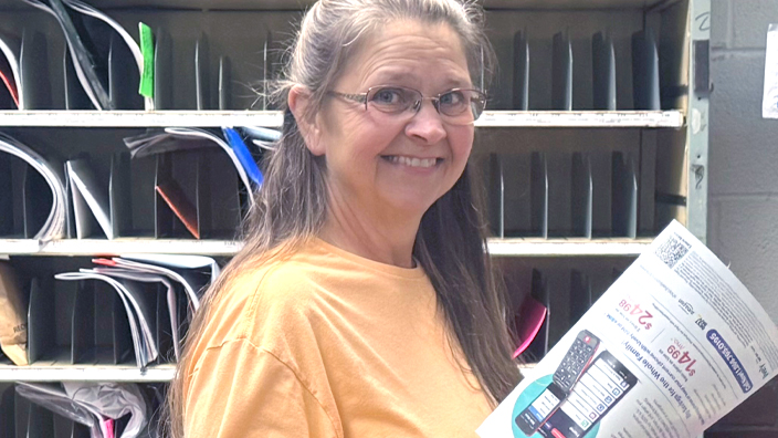 A woman with long hair wearing a light orange long-sleeve shirt