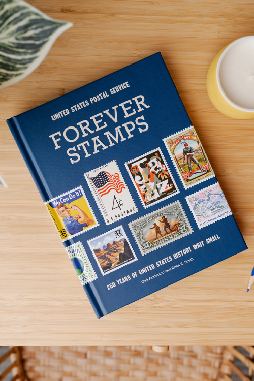 A book with U.S. postage stamps on the cover sitting on a wooden table