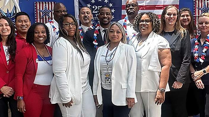 Large group of people wearing red, white and blue standing in a Post Office lobby