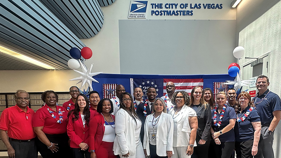 Large group of people wearing red, white and blue standing in a Post Office lobby