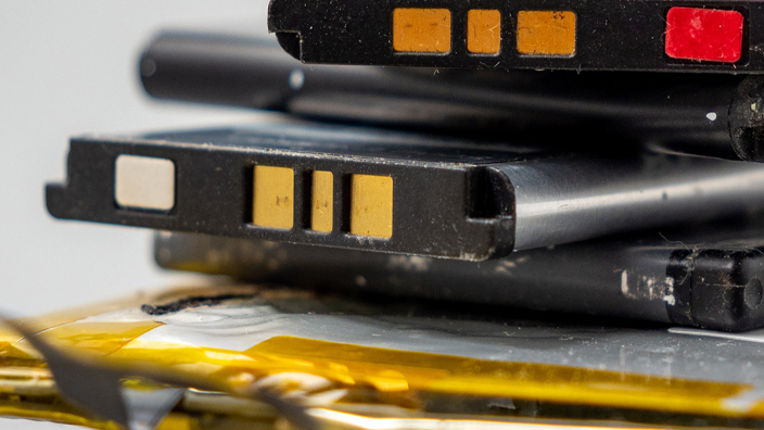 Stack of old cell phone batteries on a gray background