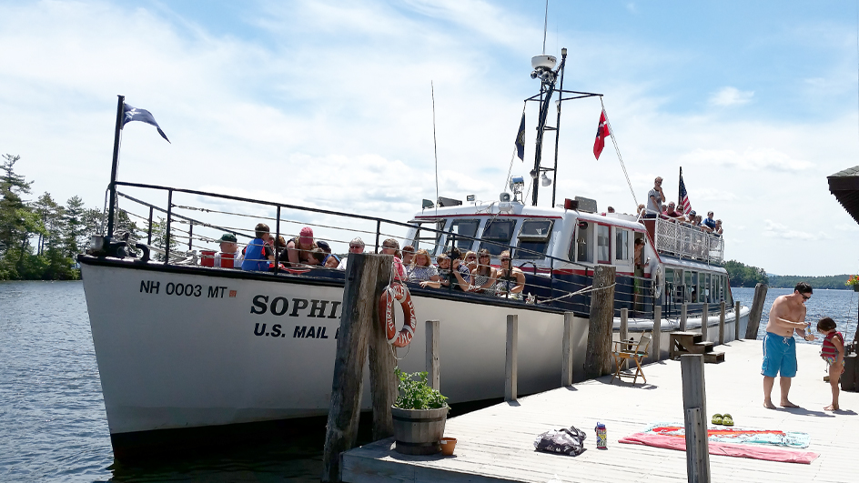 A boat with passengers is docked at a wooden pier