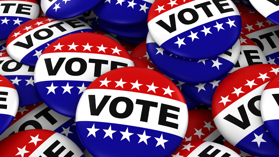 Pile of red-white-and-blue campaign buttons that read “Vote”