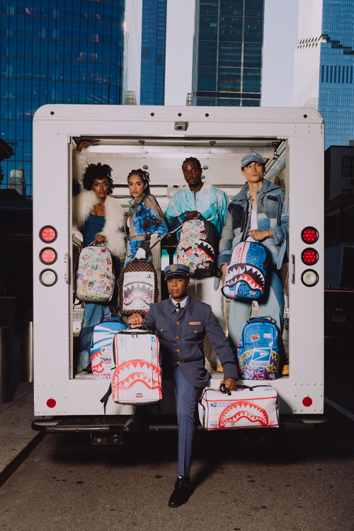 Five people standing in the back of a delivery vehicle display colorful Postal Service-themed bags and backpacks