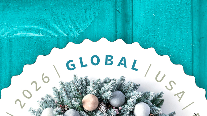A circular winter wreath stamp on a turquoise-colored door