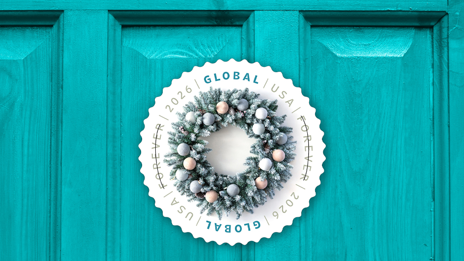 A circular winter wreath stamp on a turquoise-colored door