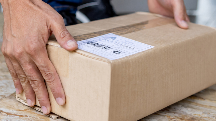 Close-up on a man picking up a package left on the porch of his house