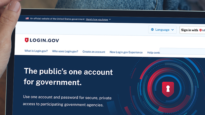 Person holding a tablet showing the Login.gov homepage on the screen