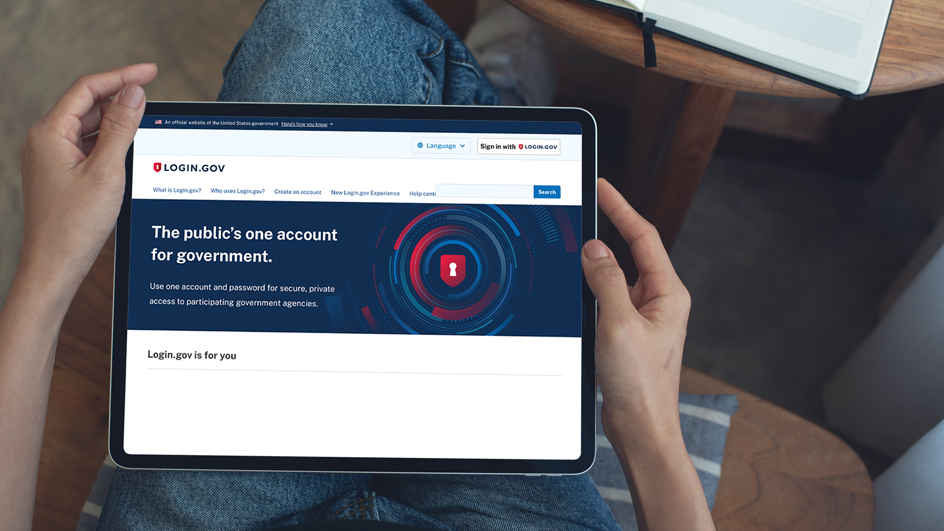 Person holding a tablet showing the Login.gov homepage on the screen