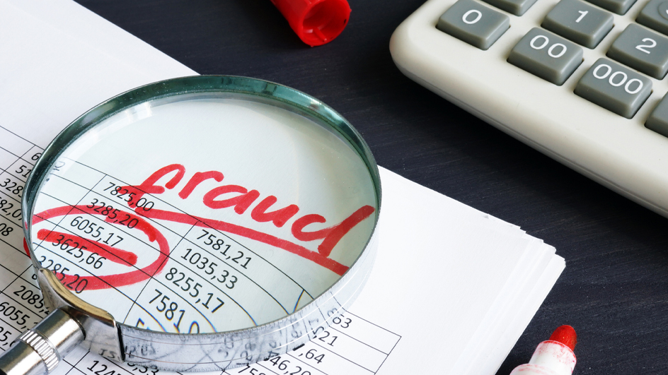 A spreadsheet of numbers with a magnifying glass on top magnifying the word fraud written in red marker