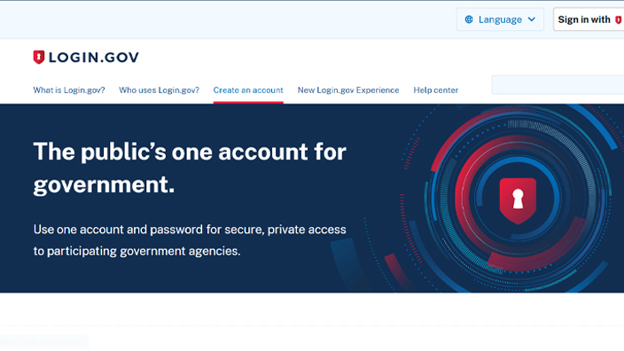 Computer sitting on top of desk displaying the Login.gov website