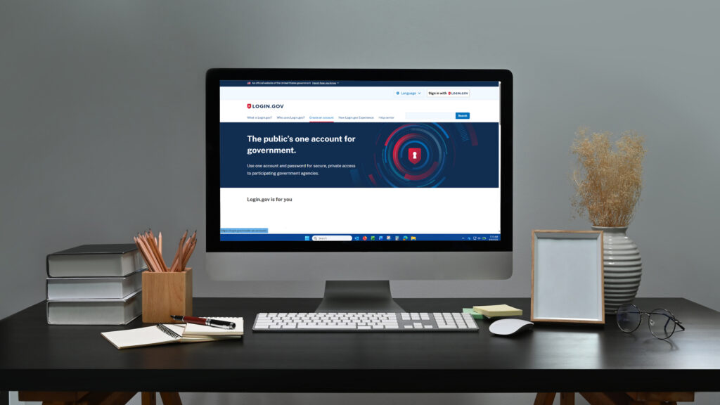 Computer sitting on top of desk displaying the Login.gov website