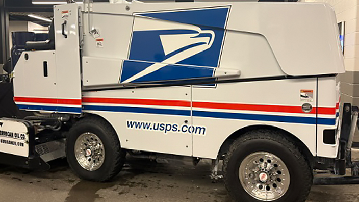 A parked Zamboni ice-resurfacing vehicle with the blue USPS Sonic Eagle logo and “www.usps.com” on the side.