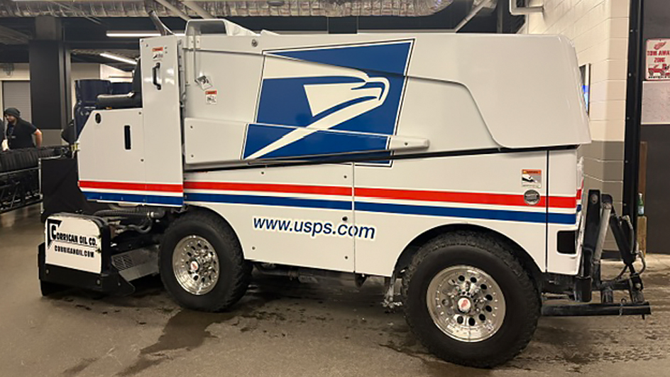 A parked Zamboni ice-resurfacing vehicle with the blue USPS Sonic Eagle logo and “www.usps.com” on the side.
